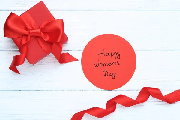 Texto Feliz Dia da Mulher com caixa de presente vermelha na mesa de madeira — Fotografia de Stock