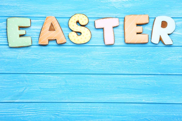 Word Easter by gingerbread cookies on blue wooden table — Stock Photo, Image