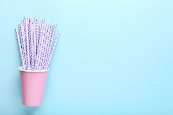 Tazas de papel rosa con pajitas sobre fondo azul —  Fotos de Stock