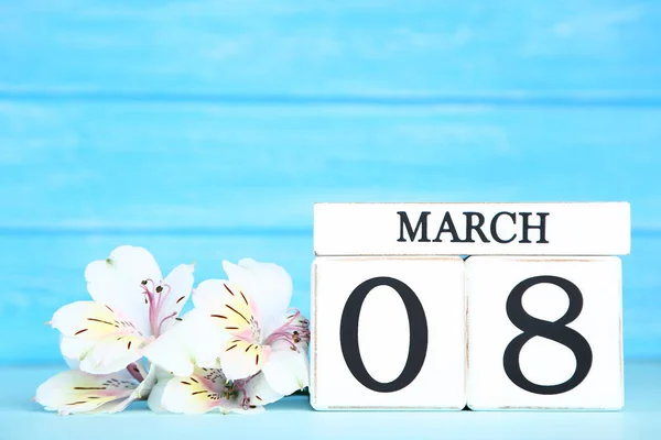 Día de la Mujer en calendario de madera con flores de alstroemeria en azul — Foto de Stock