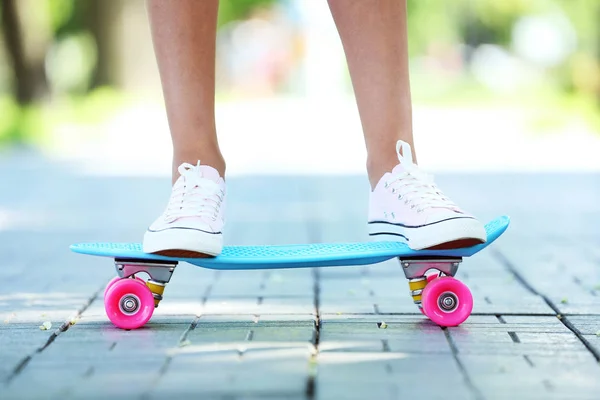 Girl standing on skateboard in the park — Stock Photo, Image