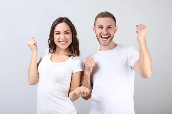 Feliz joven pareja sobre fondo gris — Foto de Stock