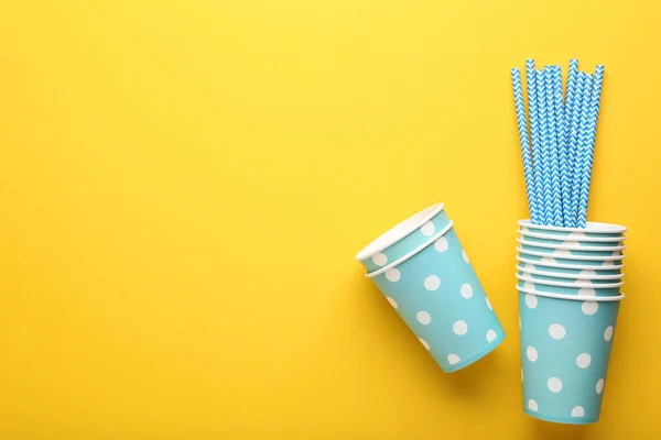 Blå pappersmuggar med sugrör på gul bakgrund — Stockfoto