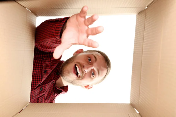 Młody człowiek szuka w pudełku — Zdjęcie stockowe