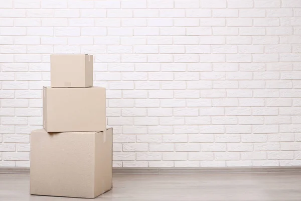 Cardboard boxes on brick wall background — Stock Photo, Image
