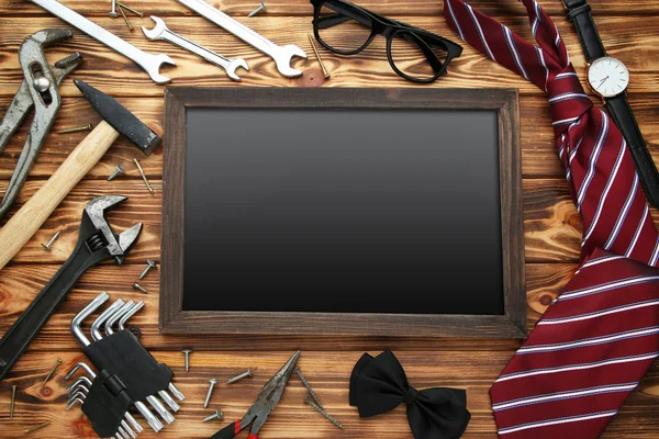 Различные инструменты с черной рамой и галстуком на коричневом деревянном столе — стоковое фото