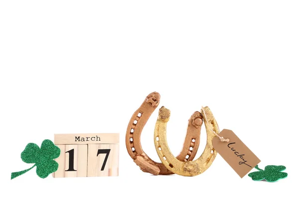 Dia de São Patrício. ferraduras douradas com folha de trevo e madeira — Fotografia de Stock