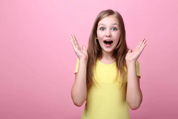 Здивована молода дівчина на рожевому фоні — стокове фото