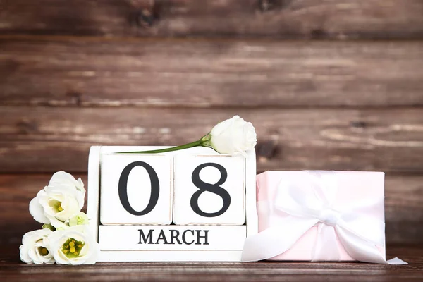 Día de la Mujer en calendario de madera con flores eustoma y caja de regalo —  Fotos de Stock