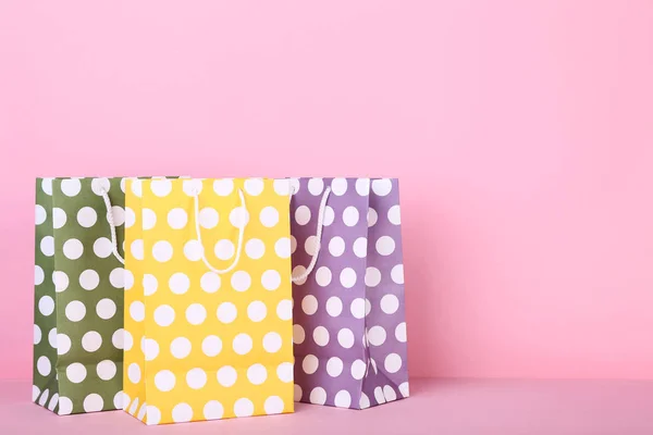 Bolsas de compras de papel de colores sobre fondo rosa — Foto de Stock