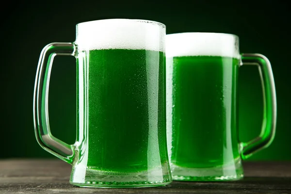 Den svatého Patrika. Zelené pivo v hrnky na tmavém pozadí — Stock fotografie