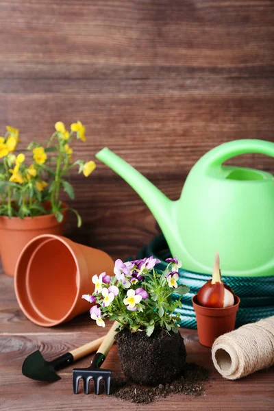 Peralatan kebun dengan bunga di atas meja kayu cokelat — Stok Foto