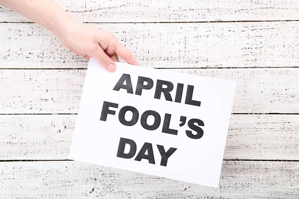 Inscriptie April Fool's Day op papier in vrouwelijke hand — Stockfoto