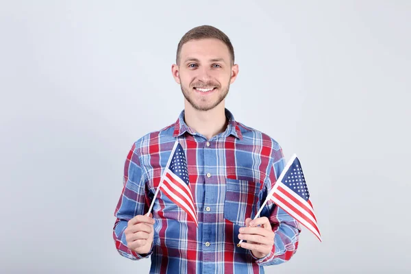 Jonge man met een Amerikaanse vlag op de grijze achtergrond — Stockfoto