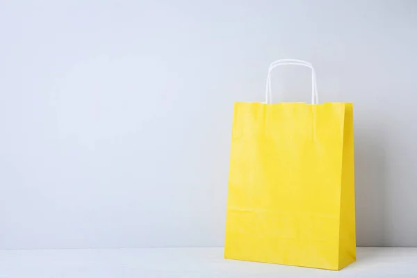Bolso de compras amarillo sobre fondo gris —  Fotos de Stock