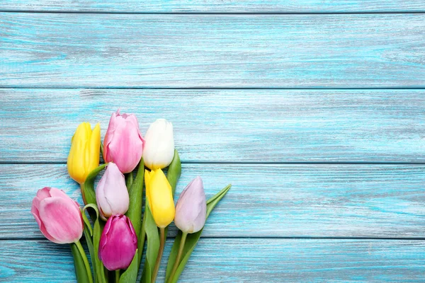 Bouquet of tulips on blue wooden table — Stock Photo, Image