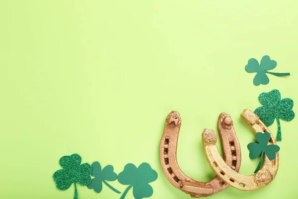 St.Patrick's Day. Golden horseshoes with clover leafs on green b — Stock Photo, Image