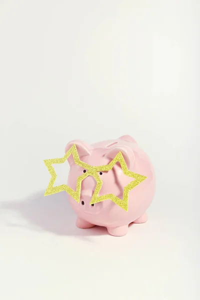 Piggybank com óculos em forma de estrela no fundo branco. Min. — Fotografia de Stock