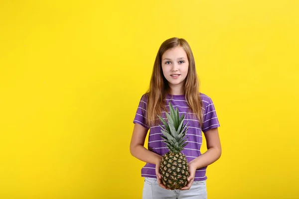 Menina bonito com abacaxi no fundo amarelo — Fotografia de Stock