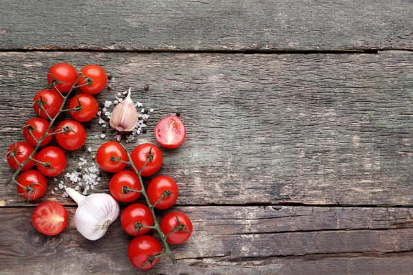 Tomat ceri dengan bawang putih dan rempah-rempah di atas meja kayu abu-abu — Stok Foto