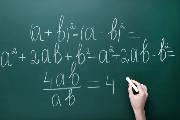 Γυναικείο χέρι γραπτώς οι μαθηματικοί τύποι για μαυροπίνακα — Φωτογραφία Αρχείου