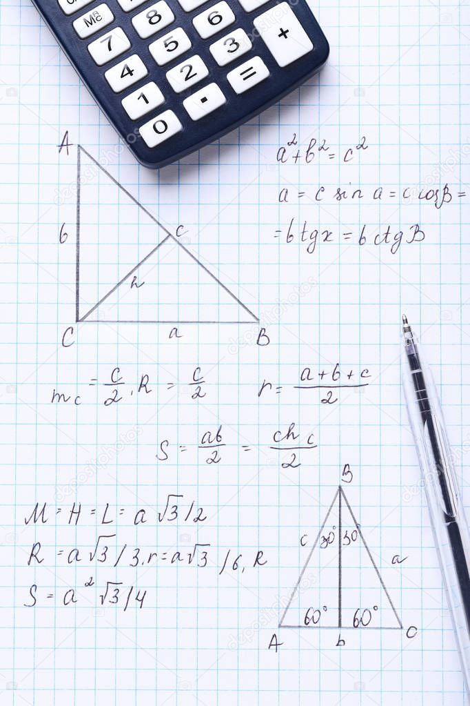 Exercise book with maths formulas and calculator