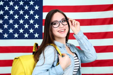 Amerikan bayrağı arka plan üzerinde sırt çantası ile genç öğrenci