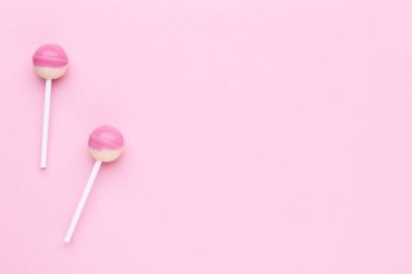 Pembe bir arka plan üzerinde tatlı lolipop
