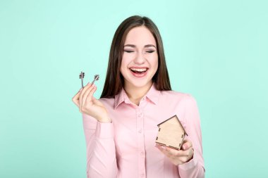 Genç kadın anahtarları ve ahşap ev nane arka plan üzerinde gösterilen