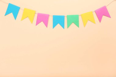 Bej renkli arka plan üzerinde asılı renkli kağıt bayrak