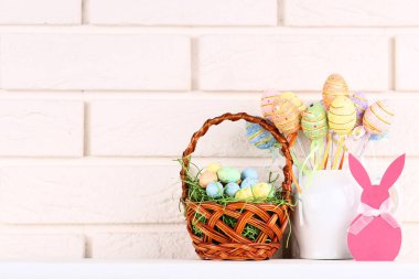 Tuğla duvar arka plan üzerinde renkli Paskalya yumurtaları ve kağıt tavşan