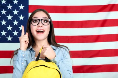 Amerikan bayrağı arka plan üzerinde sırt çantası ile genç öğrenci