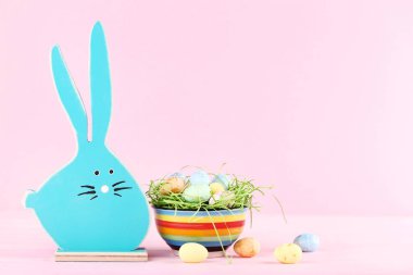 Pembe bir arka plan üzerinde Paskalya yumurta ile ahşap tavşan