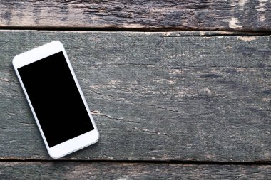 Gri ahşap masa üstünde Smartphone