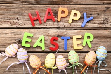 Metin mutlu Paskalya kahverengi ahşap masa üzerinde renkli yumurta