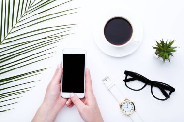 Smartphone ile kahve, eller içinde palmiye yaprağı ve gla