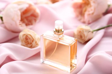 Güllü saten zemin üzerine parfüm şişesi