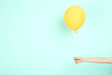 Sarı balon nane arka planda tutan el