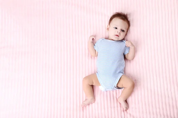 Bayi manis berbaring di tempat tidur merah muda — Stok Foto