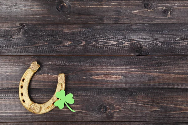 St.Patrick's Day. Χρυσή πεταλοειδή με φύλλο τριφυλλιού σε ξύλινα ta — Φωτογραφία Αρχείου