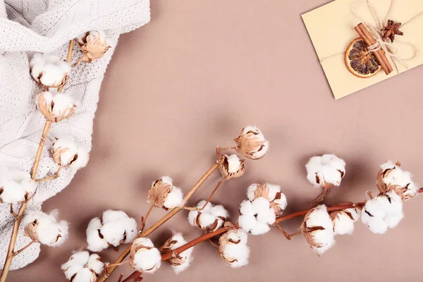 Kwiatów bawełny z sweter i koperty na brązowym tle — Zdjęcie stockowe