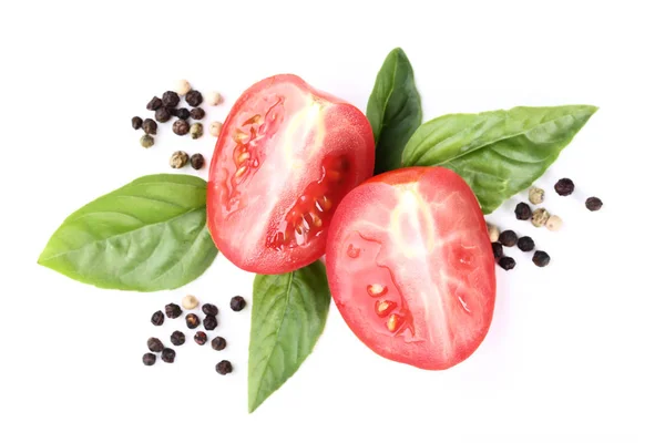 Tuoreet tomaatit basilikanlehdillä ja mausteilla eristettynä valkoisella bakilla — kuvapankkivalokuva