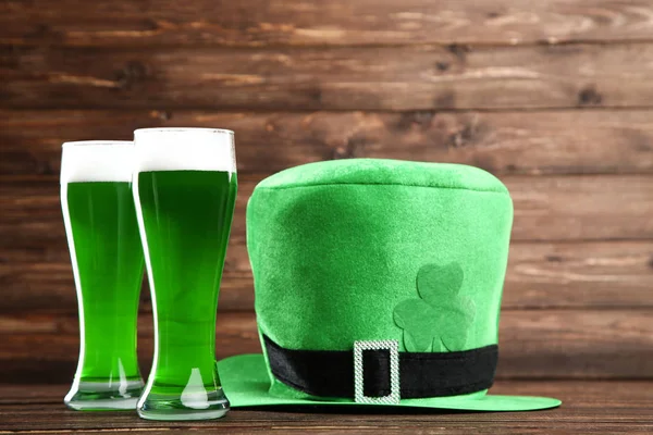 Dia de São Patrício. Copos de cerveja verde com chapéu em costas de madeira — Fotografia de Stock
