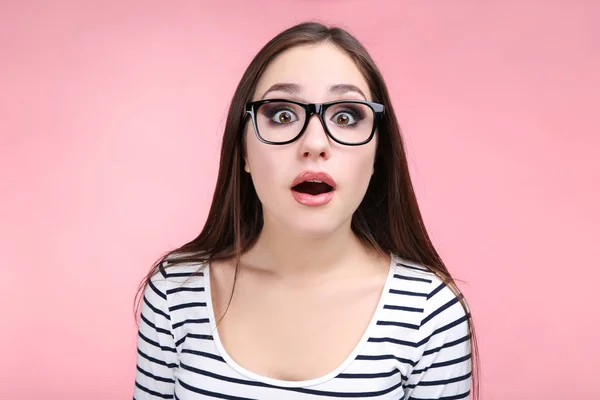 Jonge vrouw met bril op roze achtergrond — Stockfoto