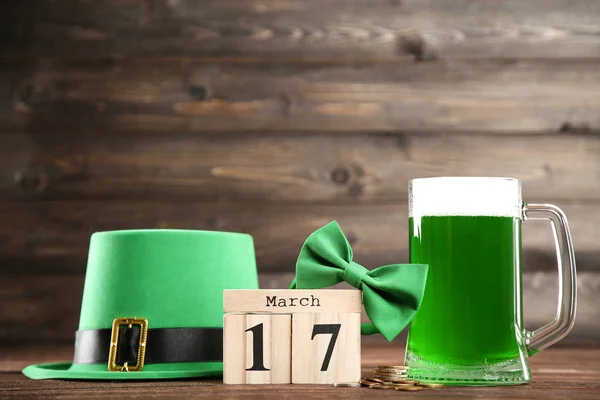 St. Patrick's Day. Zielone piwo w kubek z kapelusz, muszka i kostki — Zdjęcie stockowe