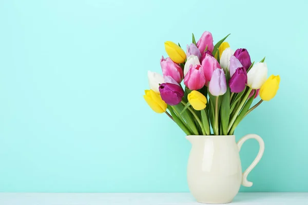 Ramo de tulipanes en jarra sobre mesa de madera —  Fotos de Stock