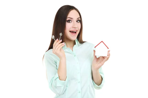 Young woman showing keys and wooden house on white background — Stock Photo, Image