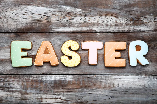 Word Easter gingerbread cookies on brown wooden table — Stock Photo, Image