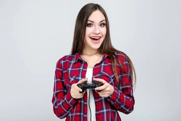 Menina bonita com joystick no fundo cinza — Fotografia de Stock