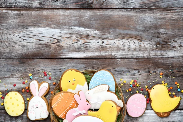 Galletas de pan de jengibre de Pascua en cesta con espolvoreos en ta de madera —  Fotos de Stock